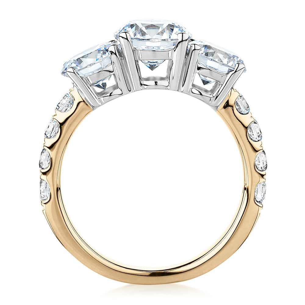 Three stone ring with 3.44 carats* of diamond simulants in 10 carat yellow and white gold