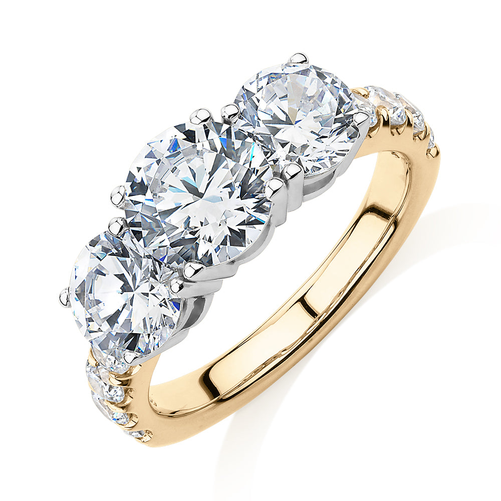 Three stone ring with 3.44 carats* of diamond simulants in 10 carat yellow and white gold
