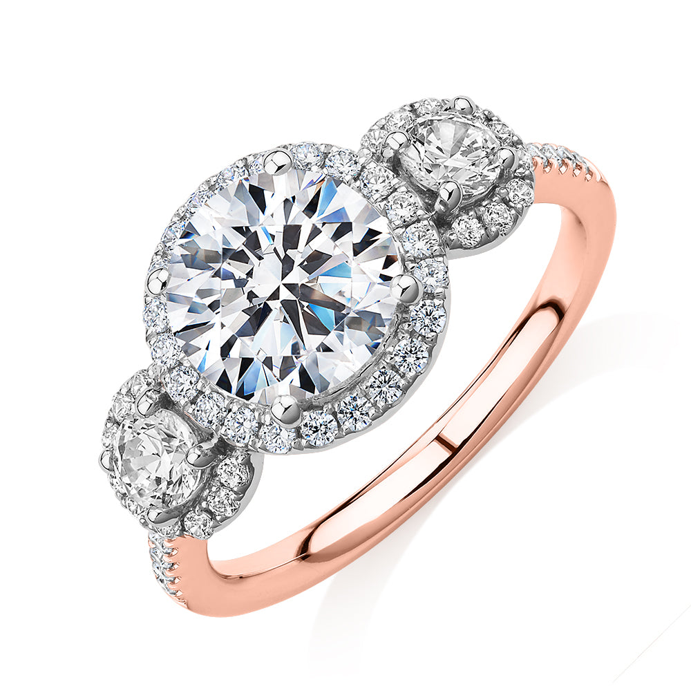 Three stone ring with 2.68 carats* of diamond simulants in 10 carat rose and white gold