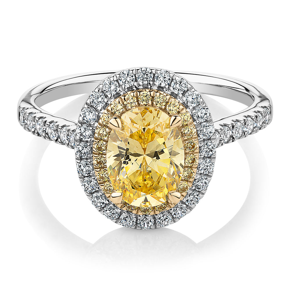 Oval and Round Brilliant halo engagement ring with 1.68 carats* of diamond simulants in 10 carat white and yellow gold