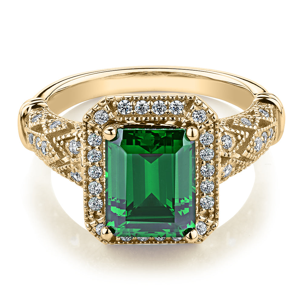 Dress ring with 9x7mm emerald simulant and 0.27 carats* of diamond simulants in 10 carat yellow gold