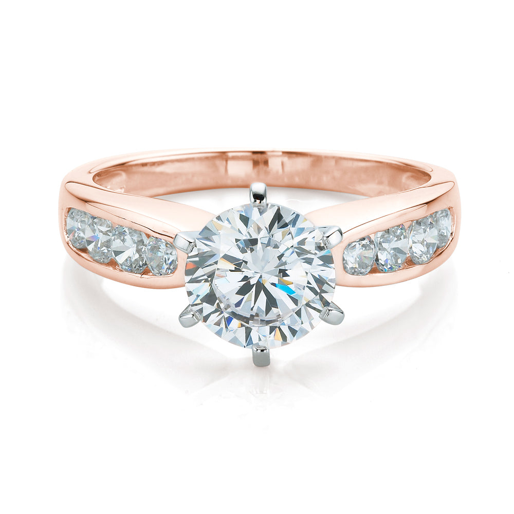 Round brilliant tapered channel set engagement ring in 14 carat rose gold with white gold setting