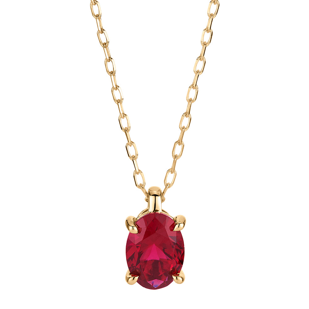 Oval solitaire pendant with ruby simulant in 10 carat yellow gold
