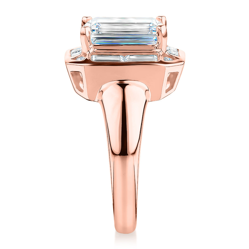 Emerald Cut, Baguette and Round Brilliant halo engagement ring with 4.53 carats* of diamond simulants in 10 carat rose gold