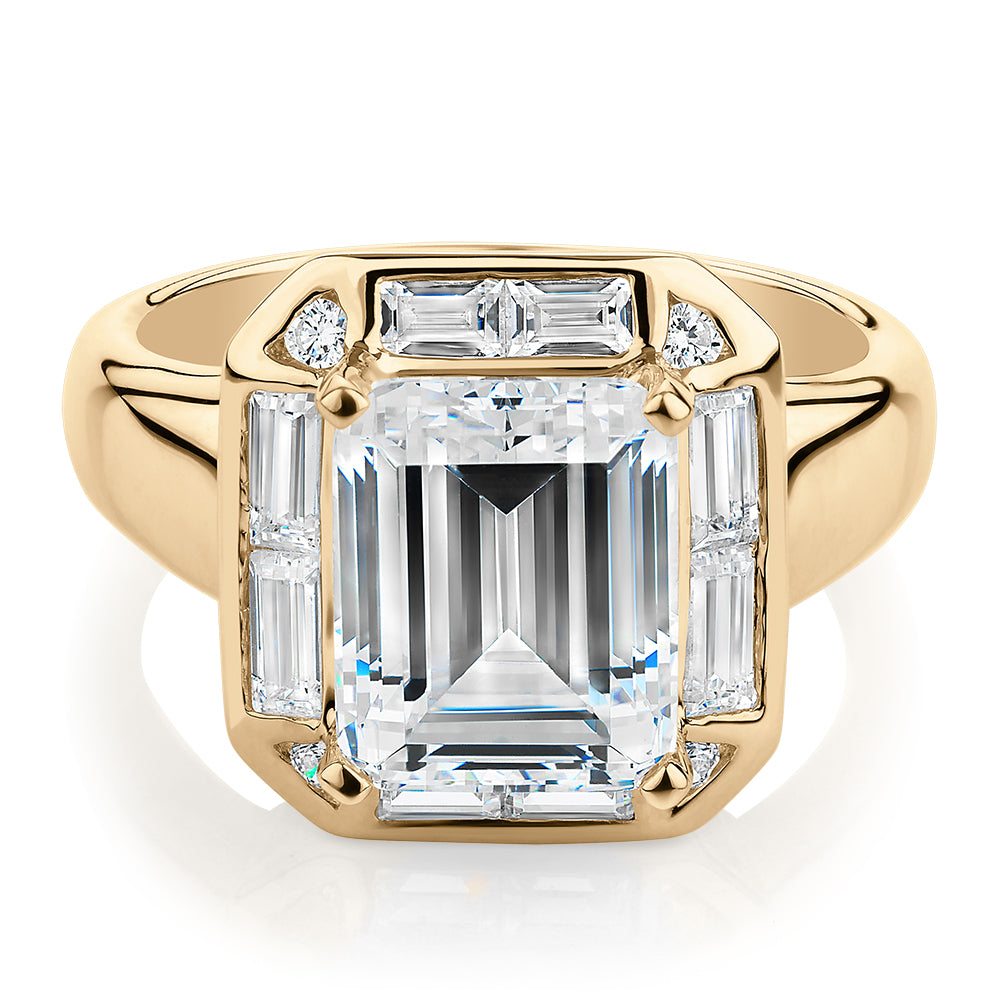 Emerald Cut, Baguette and Round Brilliant halo engagement ring with carats* of diamond simulants in 10 carat yellow gold