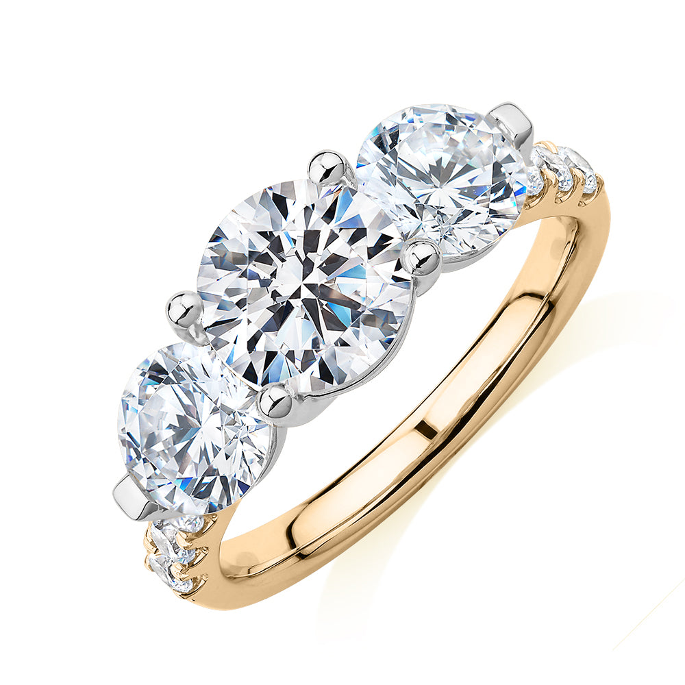 Three stone ring with 3.59 carats* of diamond simulants in 10 carat yellow and white gold