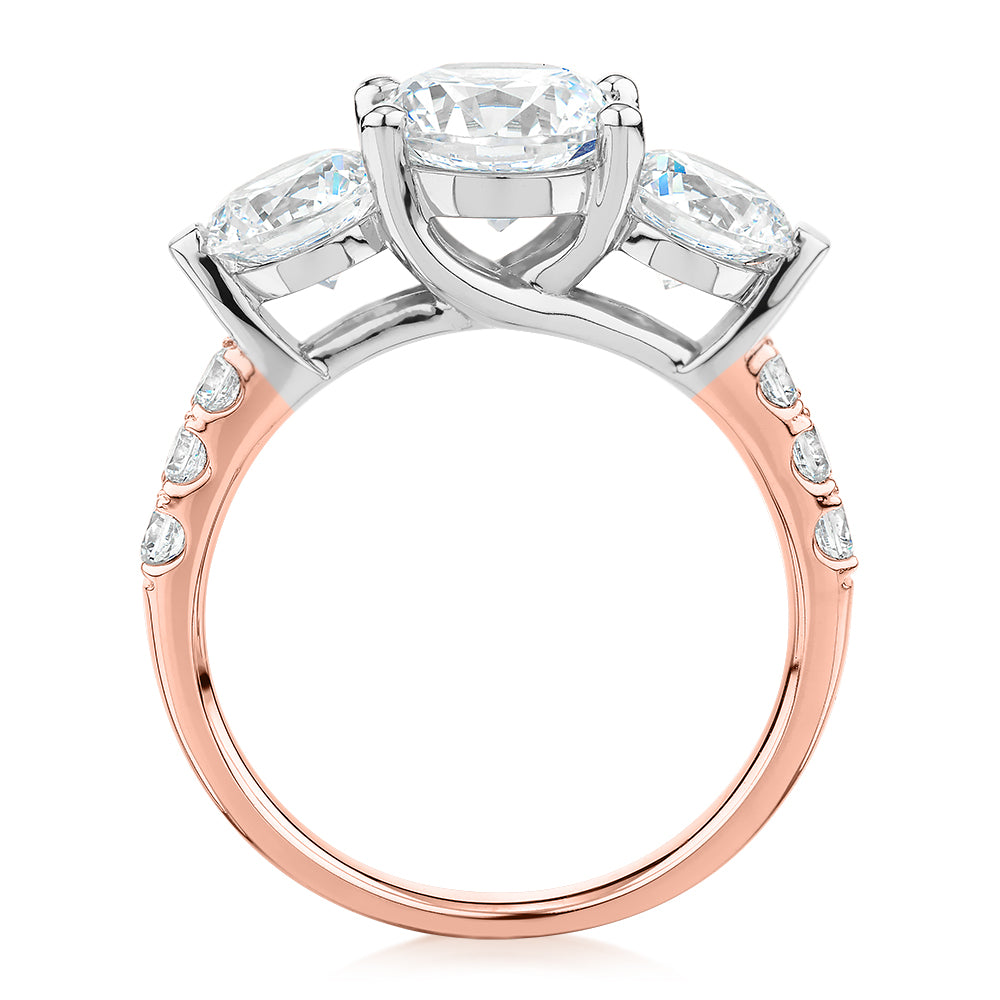 Three stone ring with 3.59 carats* of diamond simulants in 10 carat rose and white gold