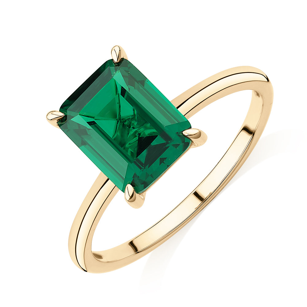 Dress ring with emerald simulant in 10 carat yellow gold