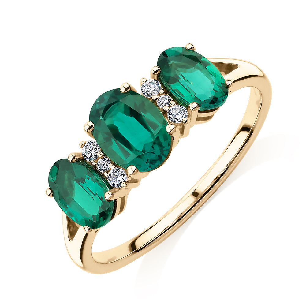Dress ring with emerald and diamond simulants in 10 carat yellow gold