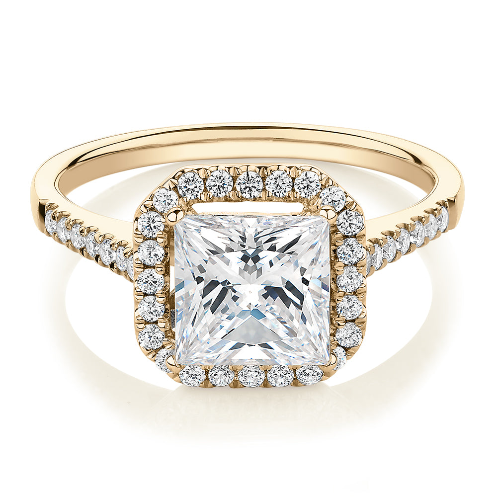 Princess Cut and Round Brilliant halo engagement ring with carats* of diamond simulants in 14 carat yellow gold