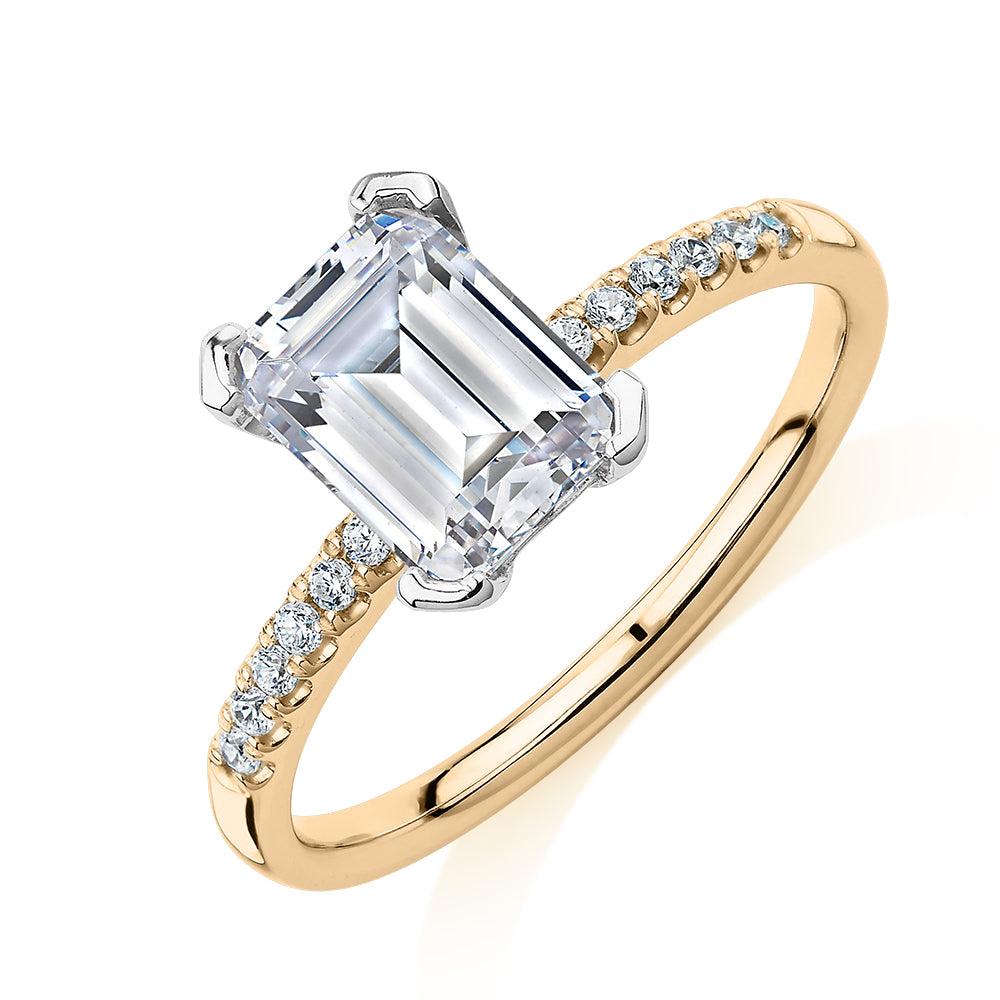 Emerald Cut and Round Brilliant shouldered engagement ring with 1.82 carats* of diamond simulants in 14 carat yellow and white gold