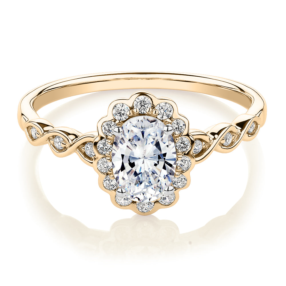 Oval and Round Brilliant halo engagement ring with 0.97 carats* of diamond simulants in 10 carat yellow gold