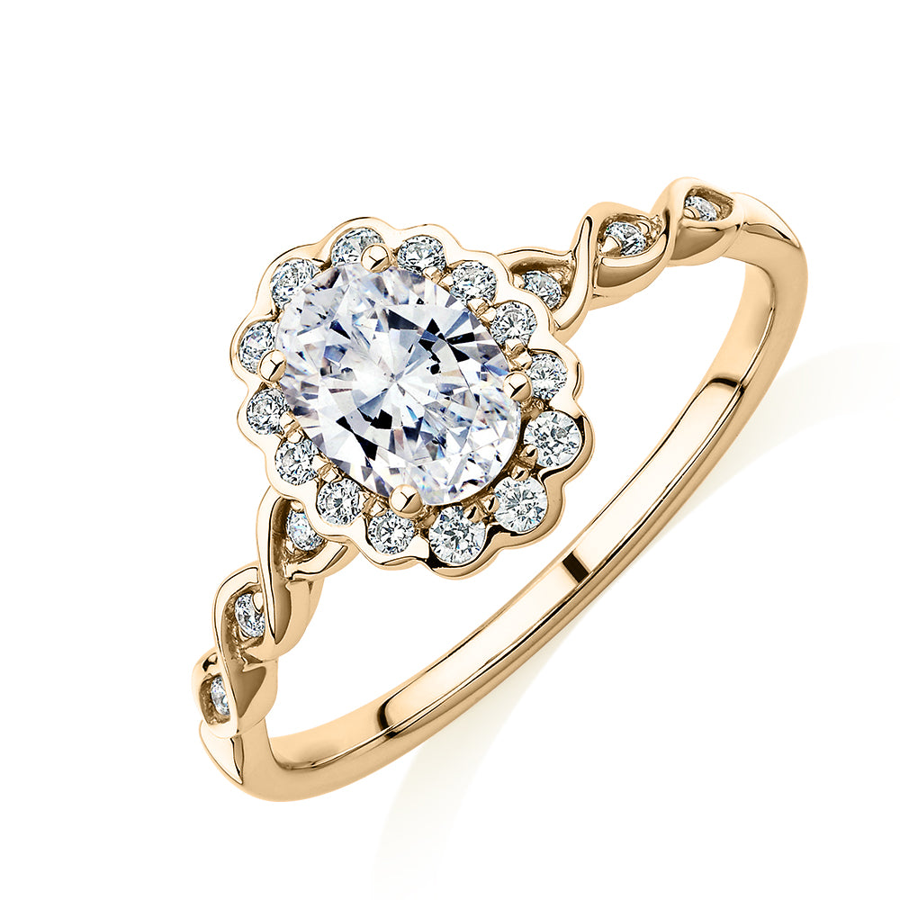 Oval and Round Brilliant halo engagement ring with 0.97 carats* of diamond simulants in 10 carat yellow gold