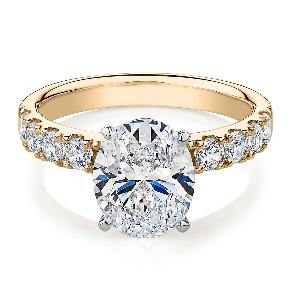 Oval shouldered engagement ring with 3.18 carats* of diamond simulants in 14 carat yellow and white gold