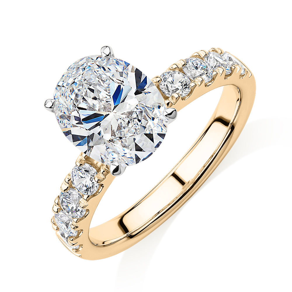 Oval shouldered engagement ring with 3.18 carats* of diamond simulants in 14 carat yellow and white gold