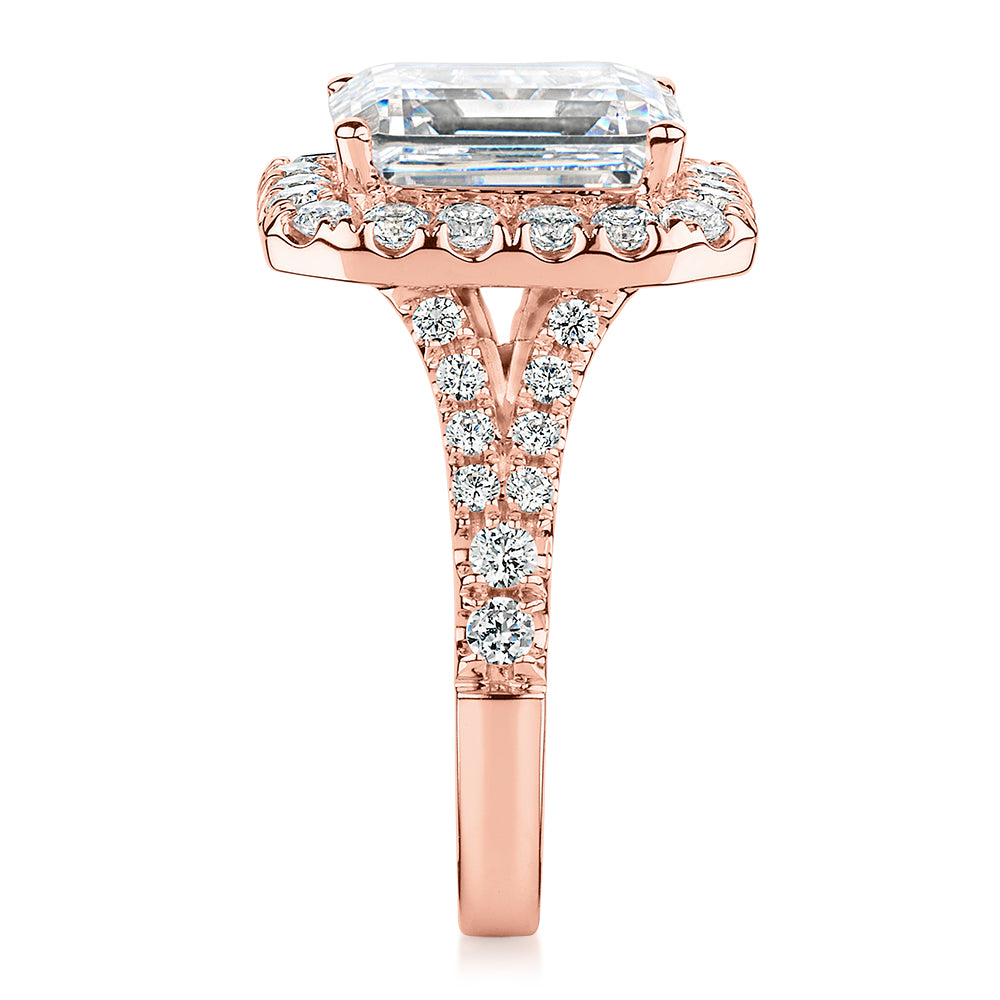 Emerald Cut and Round Brilliant halo engagement ring with 5.95 carats* of diamond simulants in 10 carat rose gold