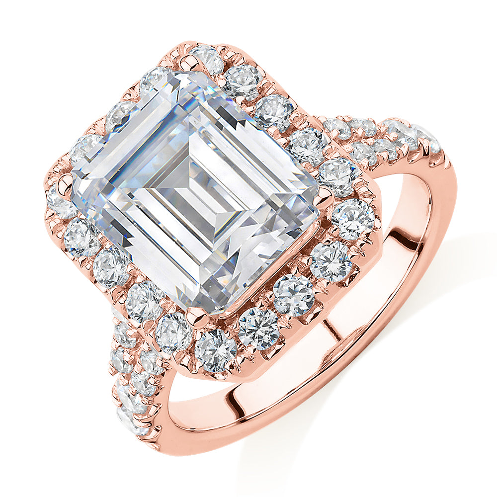 Emerald Cut and Round Brilliant halo engagement ring with 5.95 carats* of diamond simulants in 10 carat rose gold