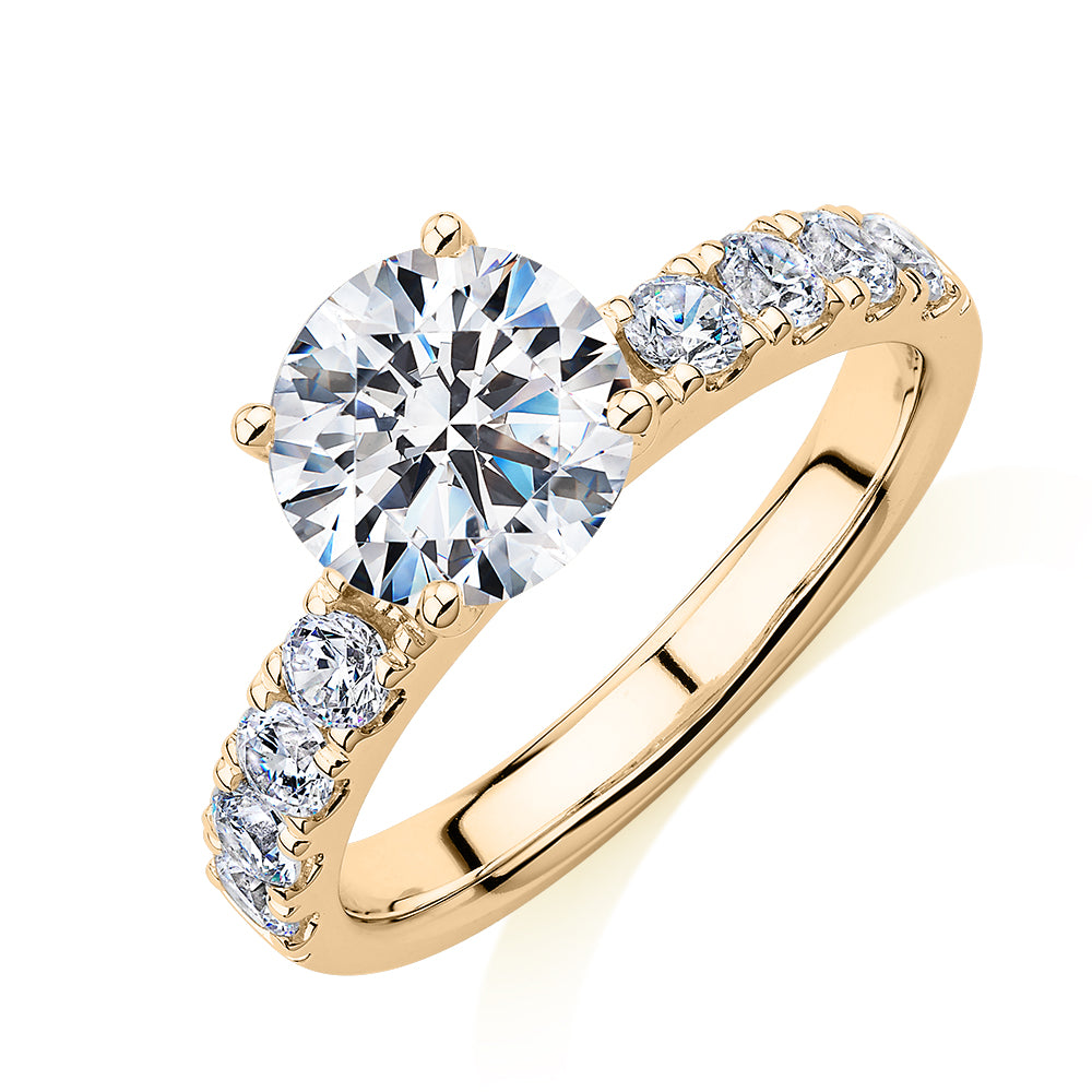Round Brilliant shouldered engagement ring with 2.68 carats* of diamond simulants in 14 carat yellow gold