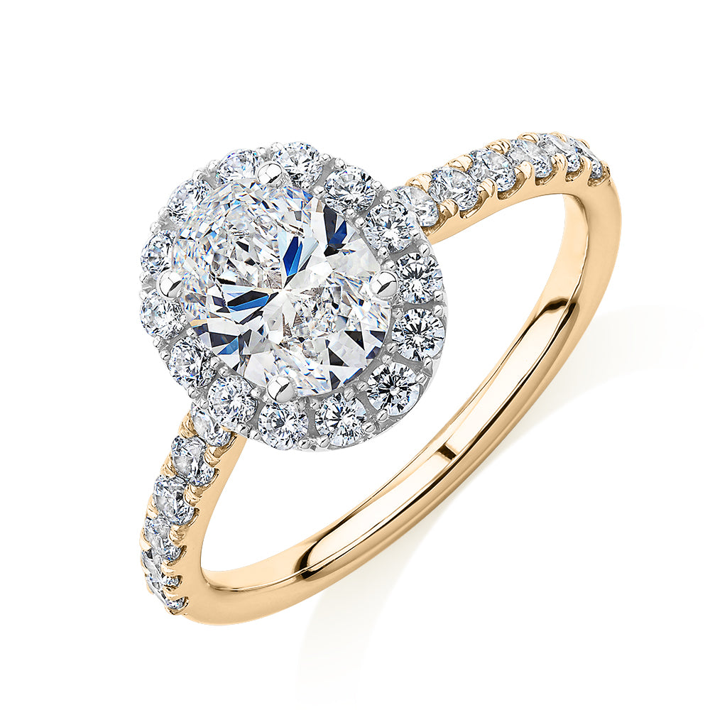 Oval and Round Brilliant halo engagement ring with 1.79 carats* of diamond simulants in 14 carat yellow and white gold