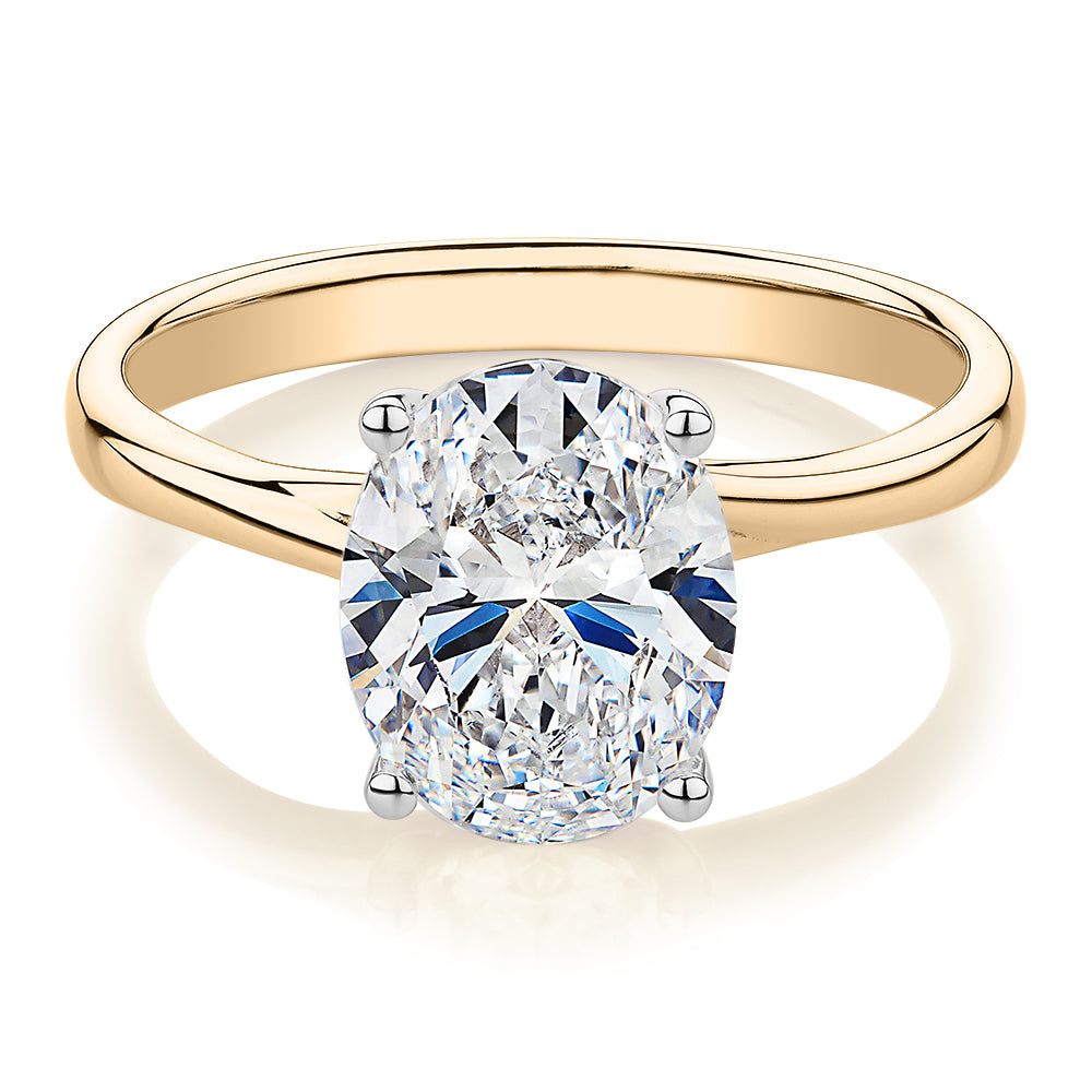 Oval solitaire engagement ring with carat* diamond simulant in 14 carat yellow and white gold