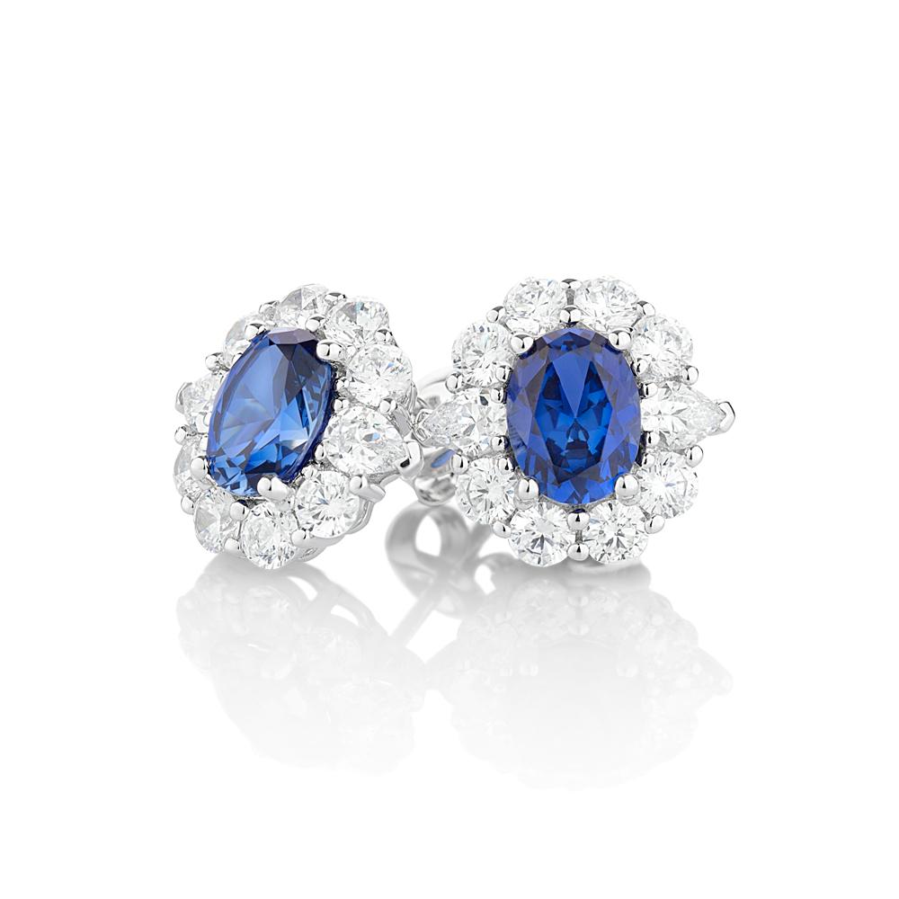 Oval and Round Brilliant stud earrings with ceylon sapphire simulants and 2.6 carats* of diamond simulants in 10 carat white gold