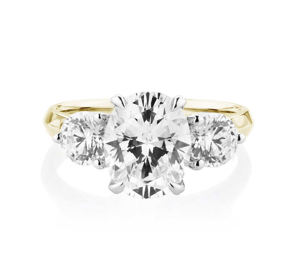 Three stone ring with 3.46 carats* of diamond simulants in 10 carat yellow and white gold