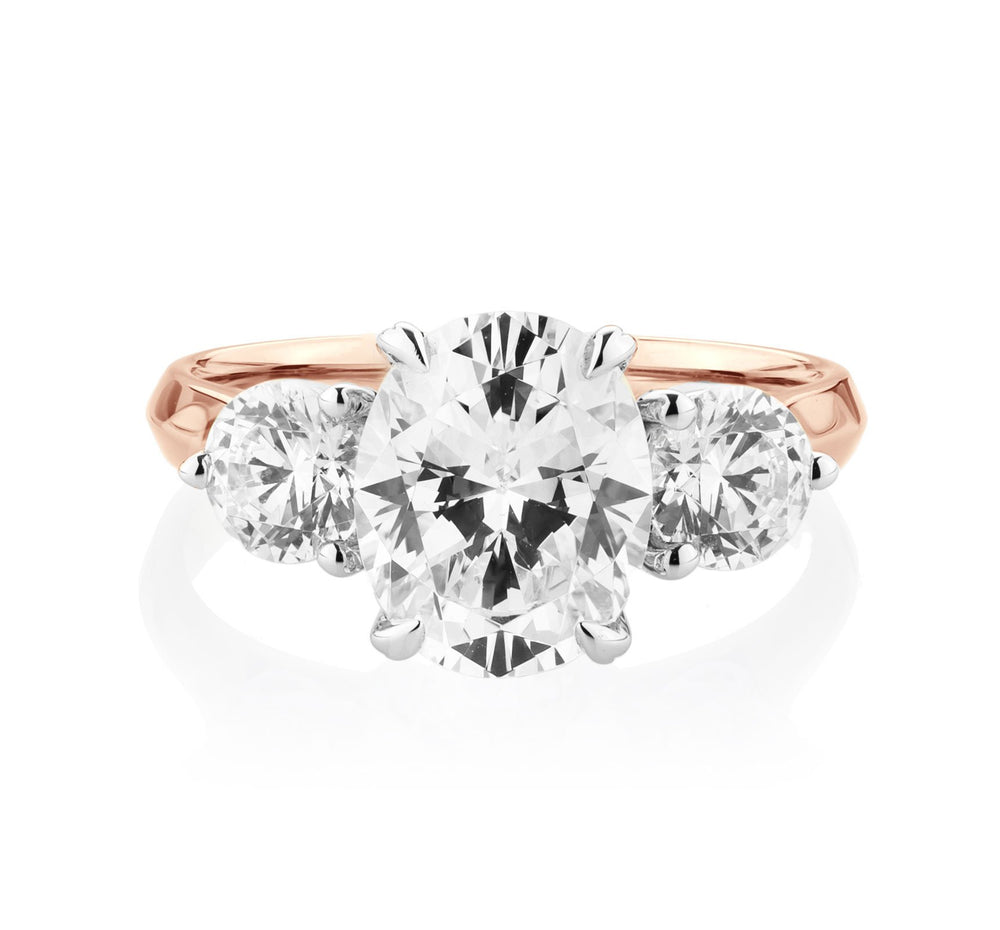 Three stone ring with 3.46 carats* of diamond simulants in 10 carat rose and white gold