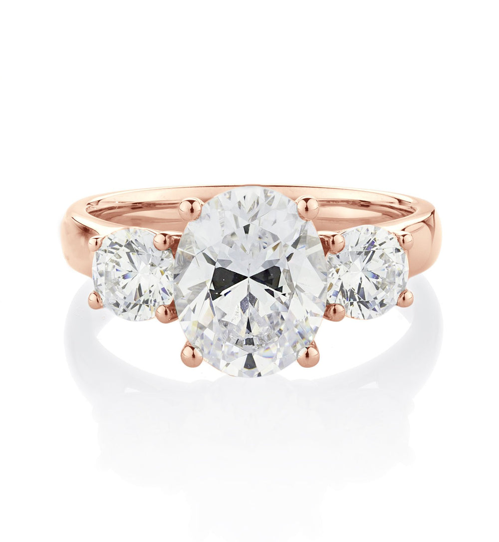 Three stone ring with 3.5 carats* of diamond simulants in 10 carat rose gold