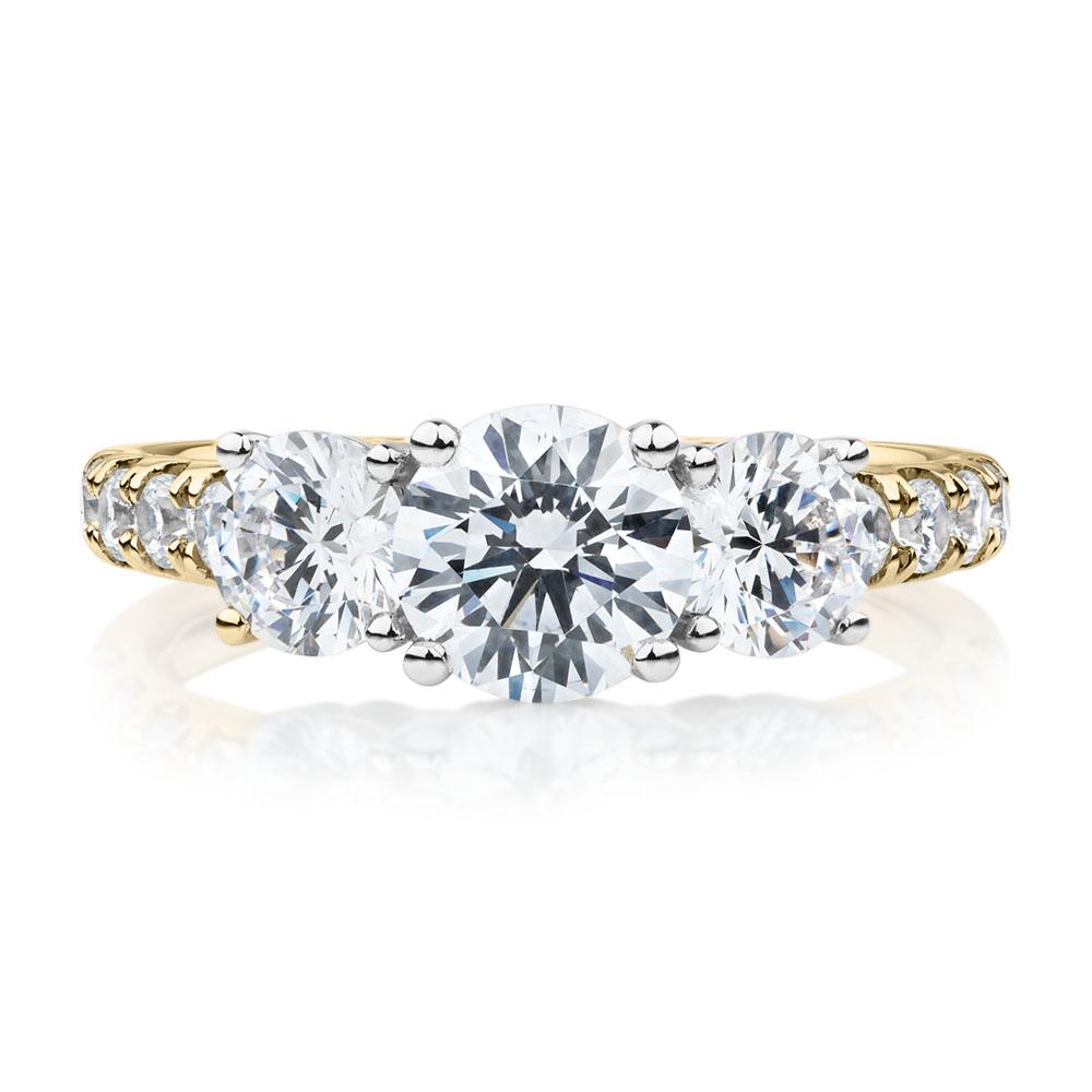 Three stone ring with 2.19 carats* of diamond simulants in 10 carat yellow and white gold