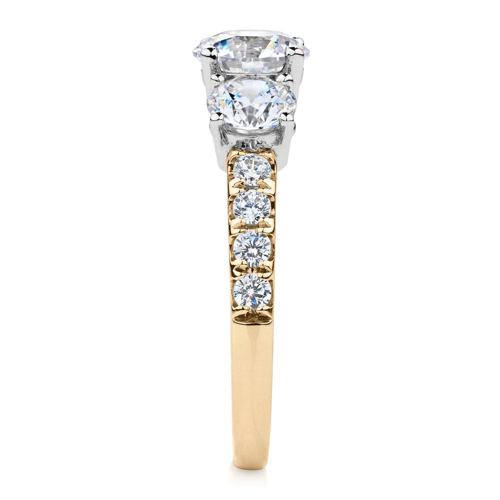 Three stone ring with 2.19 carats* of diamond simulants in 10 carat yellow and white gold