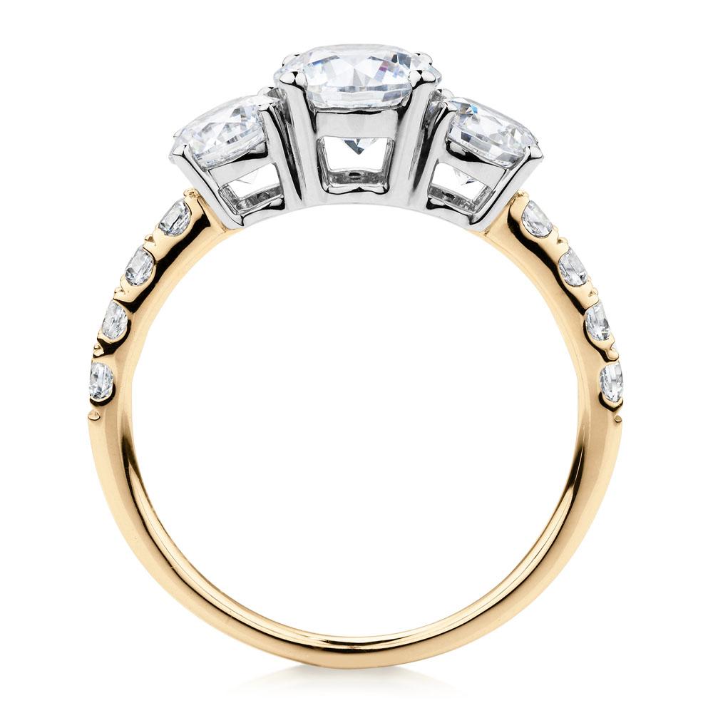 Three stone ring with 2.19 carats* of diamond simulants in 10 carat yellow and white gold