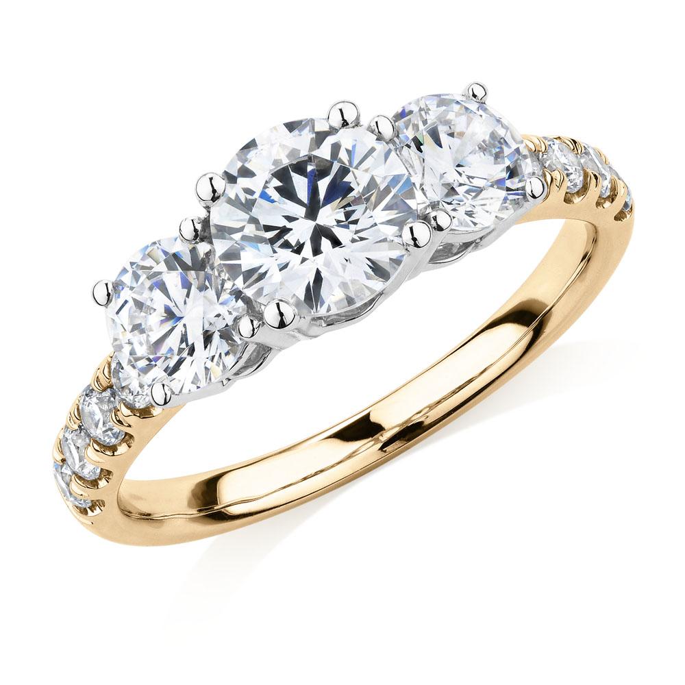 Three stone ring with 2.19 carats* of diamond simulants in 10 carat yellow and white gold