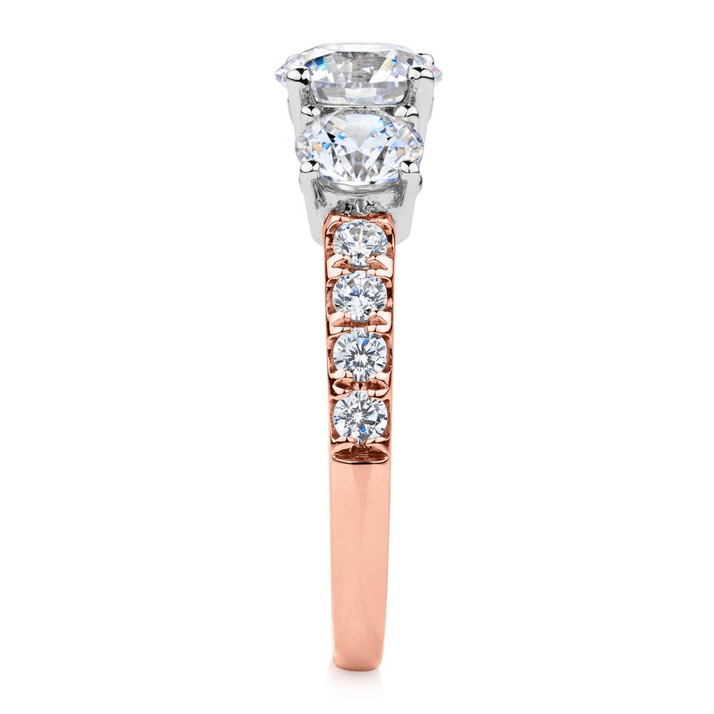 Three stone ring with 2.19 carats* of diamond simulants in 10 carat rose and white gold