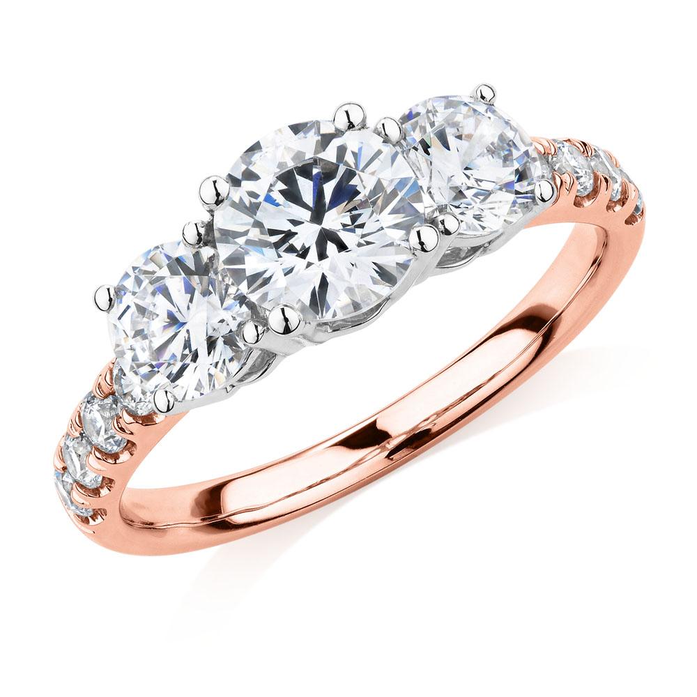 Three stone ring with 2.19 carats* of diamond simulants in 10 carat rose and white gold