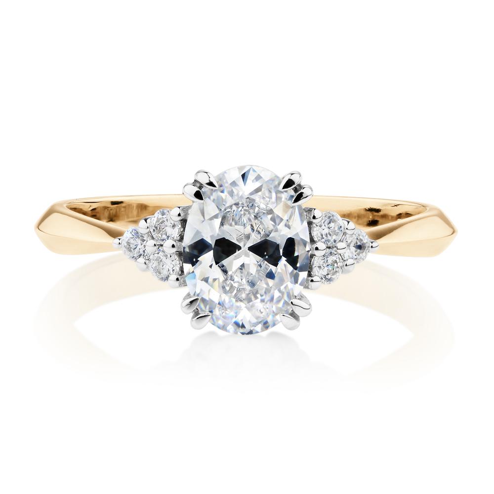 Oval and Round Brilliant shouldered engagement ring with 1.3 carats* of diamond simulants in 14 carat yellow and white gold