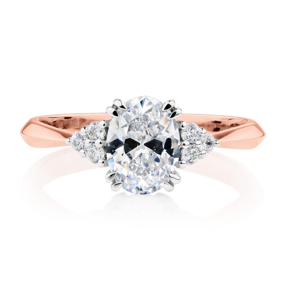 Oval and Round Brilliant shouldered engagement ring with 1.3 carats* of diamond simulants in 14 carat rose and white gold