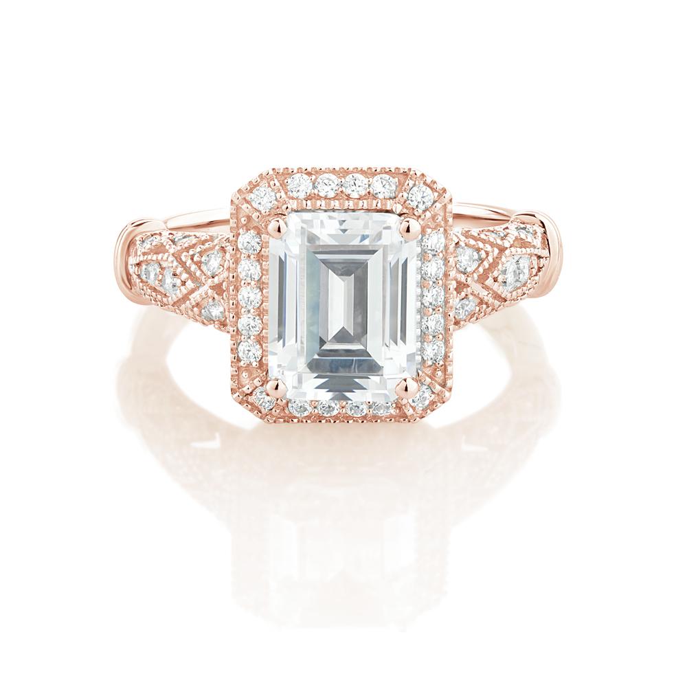 Emerald Cut and Round Brilliant halo engagement ring with 2.9 carats* of diamond simulants in 10 carat rose gold