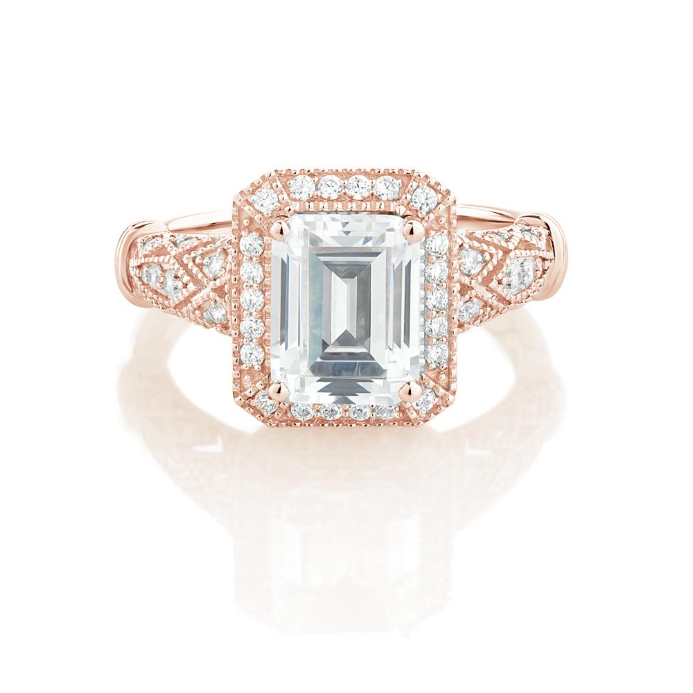 Emerald Cut and Round Brilliant halo engagement ring with 2.9 carats* of diamond simulants in 10 carat rose gold